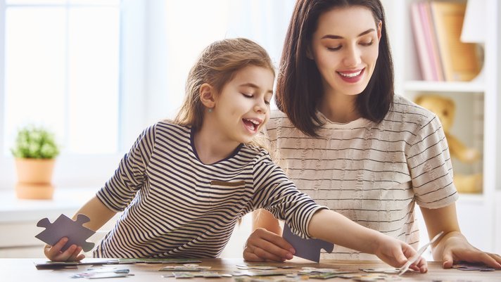 mom and daughter solving a puzzle